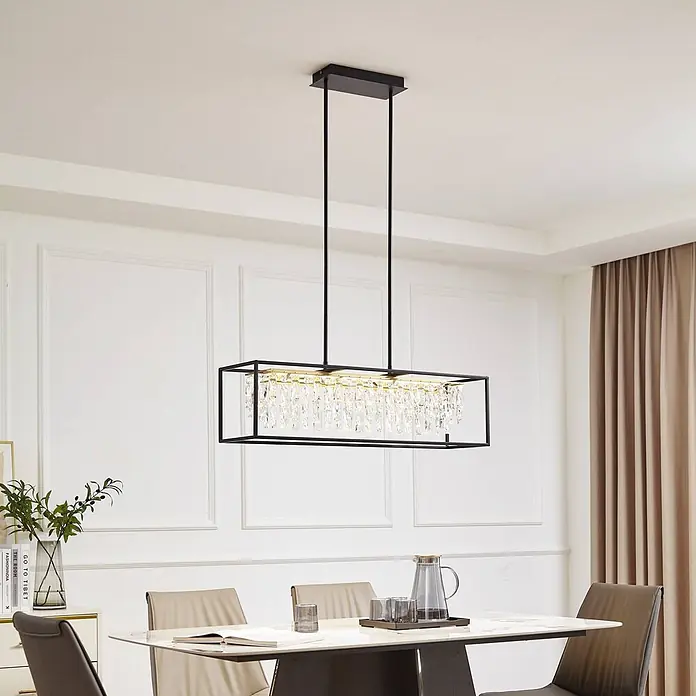Lucande Pendelleuchte Kassi - klar / transparent, gold, kristall, Schwarz - Schwarzer rechteckiger Kronleuchter mit Kristallakzenten, über einem modernen Esstisch in einem Esszimmer hängend.