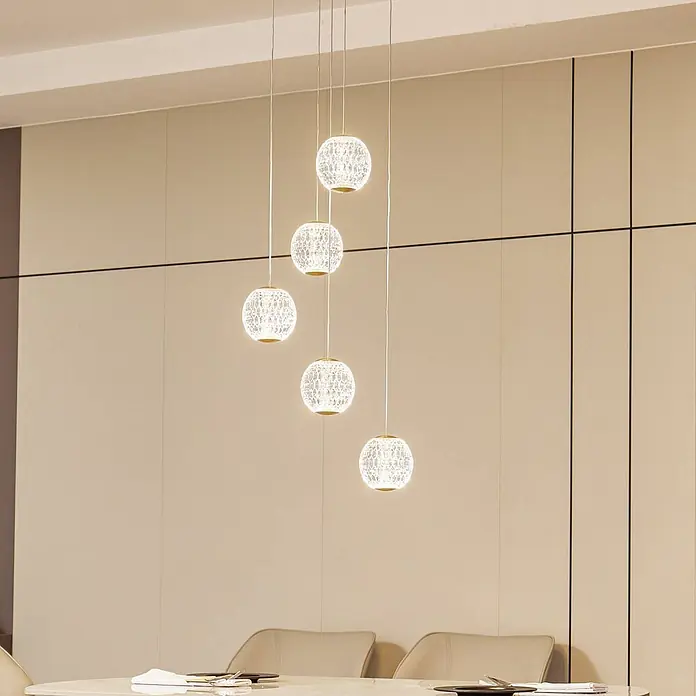 Lucande Pendelleuchte Ismenia - L x B x H: 11 x 11 x 12 cm, klar / transparent, messing antik, transparent - Fünf kugelförmige Pendelleuchten aus gemustertem Glas mit Goldakzenten hängen unterschiedlich hoch über einem Esstisch und beleuchten den Raum.