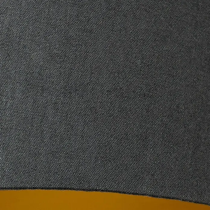 Lucande Pendelleuchte Thamila - schwarz, Schwarz, gold, messing, E27 - Dunkelgrauer strukturierter Stoff mit sichtbarer Webart, auf einer gelben Oberfläche liegend.