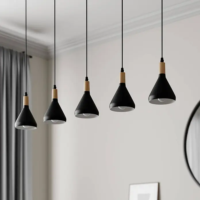 Lindby Pendelleuchte Arina - L x B x H: 100 x 12 x 17 cm, schwarz, Schwarz, holz hell, E14 - Fünf schwarze konische Pendelleuchten mit Holzdetails hängen von der Decke und leuchten nach unten.