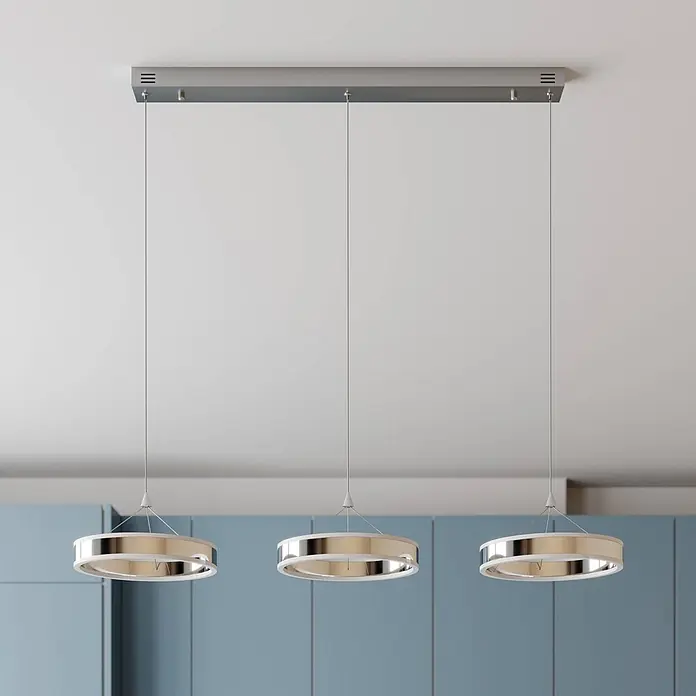Lucande Pendelleuchte Lyani - chrom / silber, chrom, weiß satiniert - Drei moderne, ringförmige Pendelleuchten mit Metallic-Finish und weißen Akzenten, von einer rechteckigen Deckenleiste abgehängt, beleuchten einen Raum.