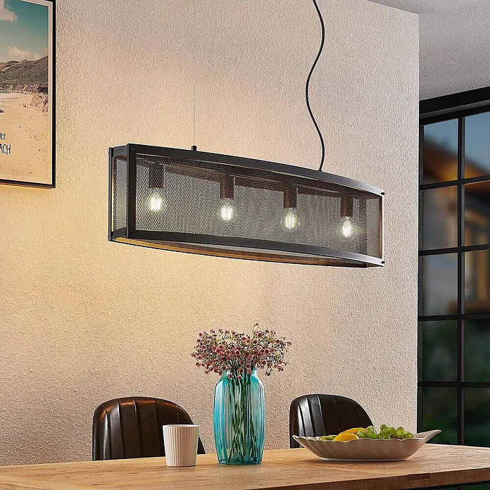 Lindby Pendelleuchte Mizgin - L x B x H: 110 x 25 x 25 cm, schwarz, Schwarz, E27 - Eine längliche Pendelleuchte aus schwarzem Metallgitter mit sichtbaren Glühbirnen hängt über einem Esstisch aus Holz und beleuchtet den Raum.