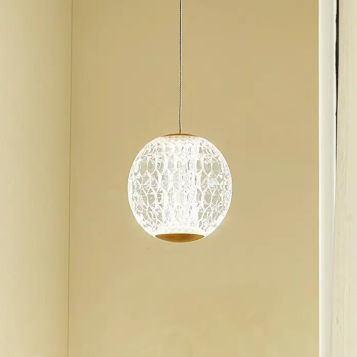 Lucande Pendelleuchte Ismenia - klar / transparent, messing antik, transparent - Eine beleuchtete kugelförmige Pendelleuchte mit klarem strukturiertem Schirm und goldenem Sockel, hängt in einem Raum.