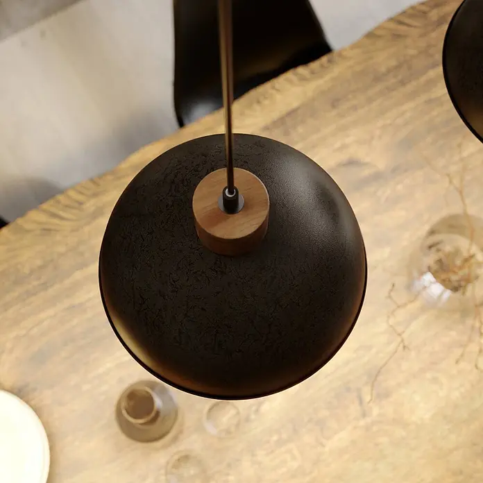 Lindby Pendelleuchte Holgar - L x B x H: 107,5 x 26,5 x 37,5 cm, alu / grau / zink, grau, holz hell, E27 - Schwarze, strukturierte Hängeleuchte mit Holzdetails über einem rustikalen Holztisch.