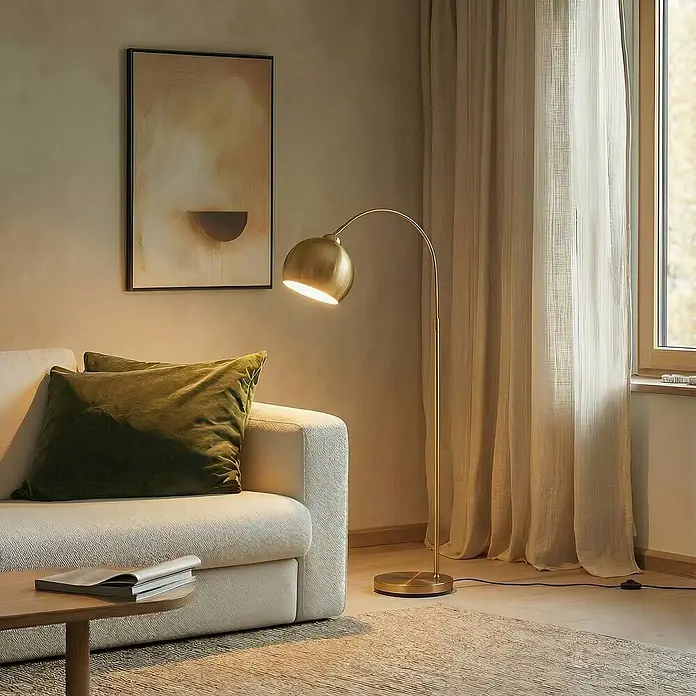 Lindby Stehleuchte Moisia - Höhe: 150 cm, messing / gold, messing / gold, E27 - Geschwungene messingfarbene Stehlampe, die neben einem weißen Sofa im Wohnzimmer warmes Licht spendet.