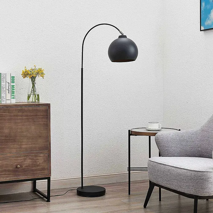 Lindby Stehleuchte Minali - Höhe: 148 cm, schwarz, schwarz, E27 - Schwarze Bogen-Stehleuchte mit kugelförmigem Schirm, die einen modernen Wohnbereich beleuchtet.