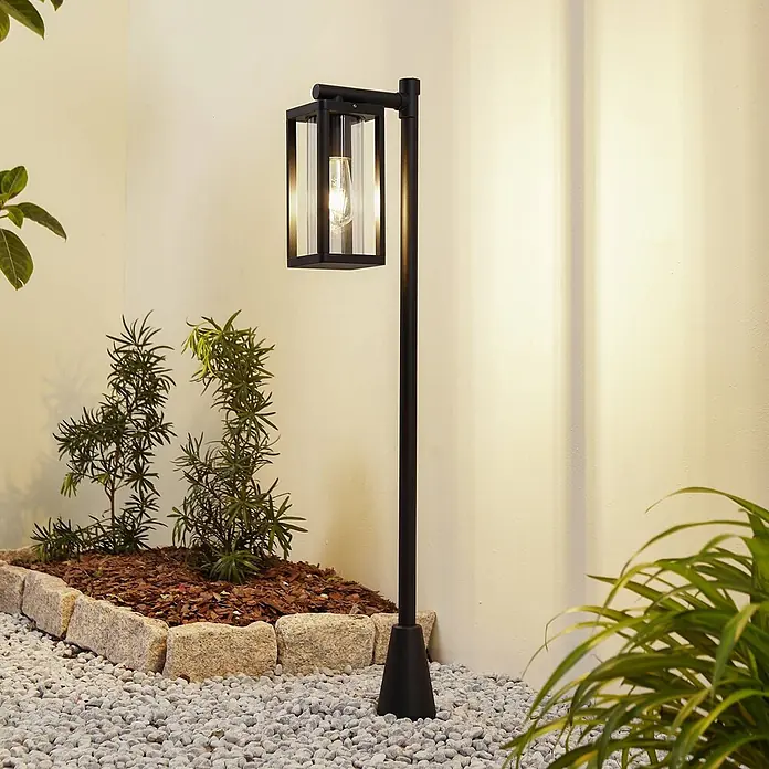 Lucande Außenlaterne Siveta -  - Schwarze Outdoor-Stehleuchte mit Klarglasschirm und sichtbarer Glühbirne, beleuchtet.