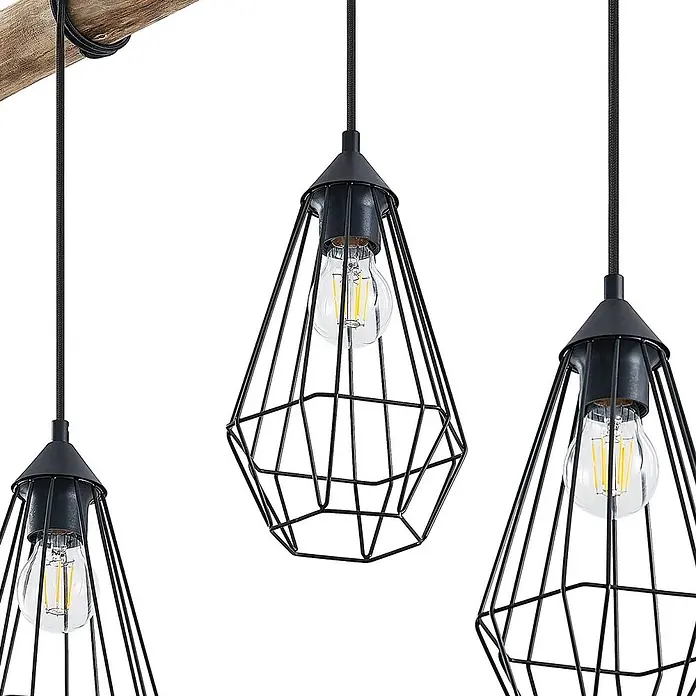 Lindby Pendelleuchte Eldarion - L x B x H: 116 x 17,5 x 25,6 cm, schwarz, Schwarz matt, holz hell, E27 - Drei Pendelleuchten mit schwarzen geometrischen Drahtkäfigen und LED-Glühbirnen, hängend an einem Holzbalken.