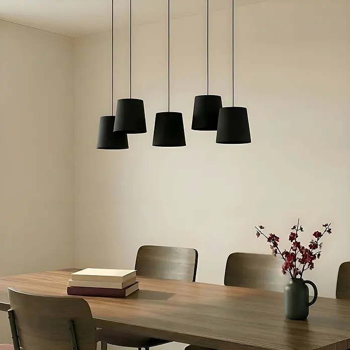 Lucande Pendelleuchte Thamila - L x B x H: 113 x 53 x 21 cm, schwarz, Schwarz, holz hell, E27 - Fünf schwarze Pendelleuchten hängen über einem Holzesstisch.