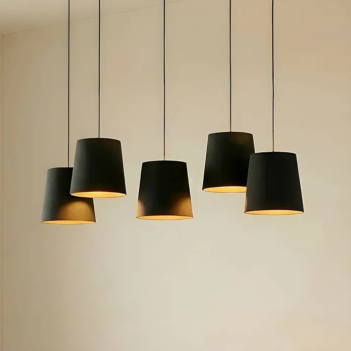 Lucande Pendelleuchte Thamila - L x B x H: 113 x 53 x 21 cm, schwarz, Schwarz, holz hell, E27 - Fünf schwarze Hängeleuchten mit hellen Innenseiten hängen von der Decke und strahlen warmes Licht nach unten ab.
