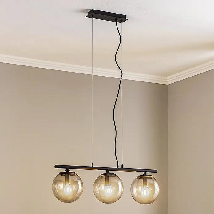 Lucande Pendelleuchte Sotiana - alu / grau / zink, rauchgrau, Schwarz, E14 - Schwarze Pendelleuchte mit drei bernsteinfarbenen Glaskugeln, von der Decke hängend.