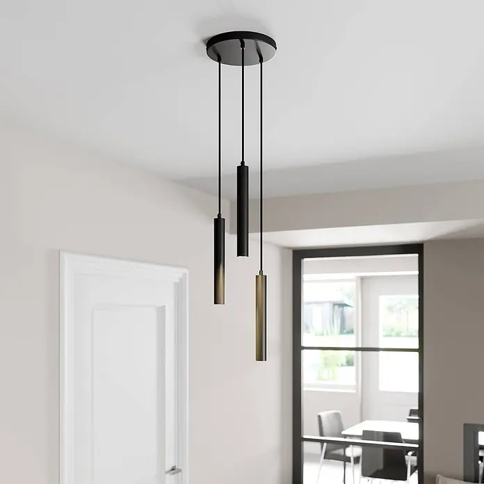 Arcchio Pendelleuchte Franka - L x B x H: 24 x 24 x 30 cm, schwarz, Schwarz (RAL 9005) - Drei schwarze und messingfarbene zylindrische Pendelleuchten hängen von einer schwarzen runden Deckenplatte in einem modernen Raum.