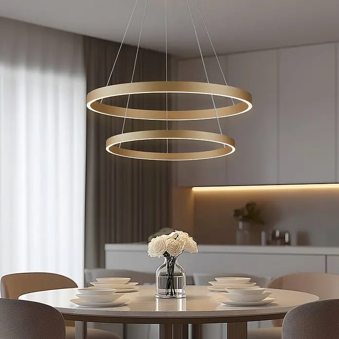 Lucande Pendelleuchte Yonam - messing / gold, gold - Zweistufige goldene LED-Pendelleuchte, die einen modernen Esstisch beleuchtet.