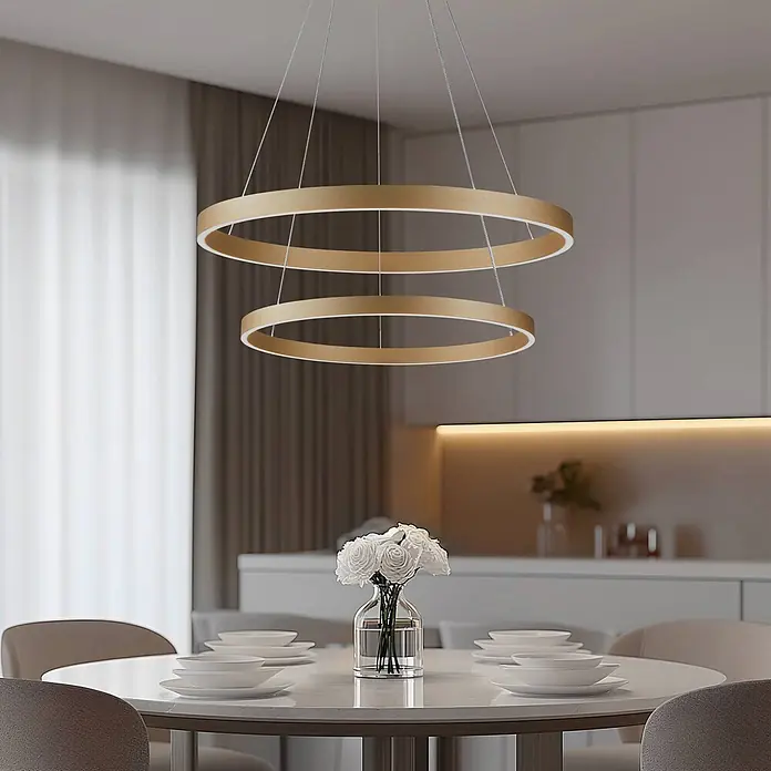 Lucande Pendelleuchte Yonam - messing / gold, gold - Zwei goldfarbene LED-Ringe bilden eine moderne Pendelleuchte über einem Esstisch.