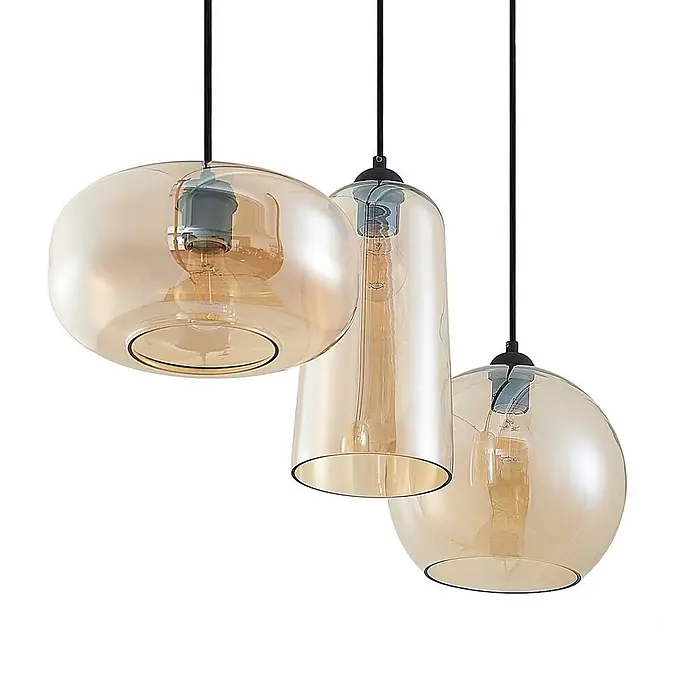 Lucande Pendelleuchte Wilja - creme / amber, Schwarz, amber, E27 - Drei Pendelleuchten mit bernsteinfarbenen Glaspendeln in verschiedenen Formen und sichtbaren Glühbirnen, aufgehängt an schwarzen Kabeln.