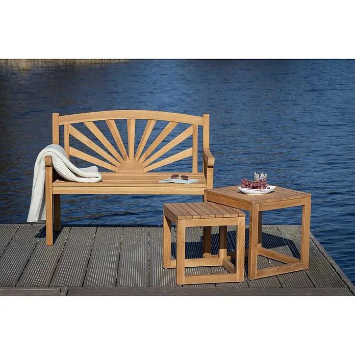 Bene Living Garten-Beistelltisch Verwood - Teakholz, Stapelbar, Quadratisch, Natur - Hölzerne Gartenbank und zwei Tische auf einem Steg am Wasser, mit Decke, Buch, Sonnenbrille und Trauben.