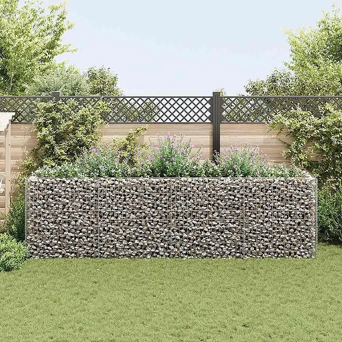 Furnicato Gabionen-Hochbeet - 90 x 360 x 100 cm - Gabionen-Hochbeet aus Drahtgitter mit Steinen gefüllt, bepflanzt mit lilafarbenen Blumen im Garten.