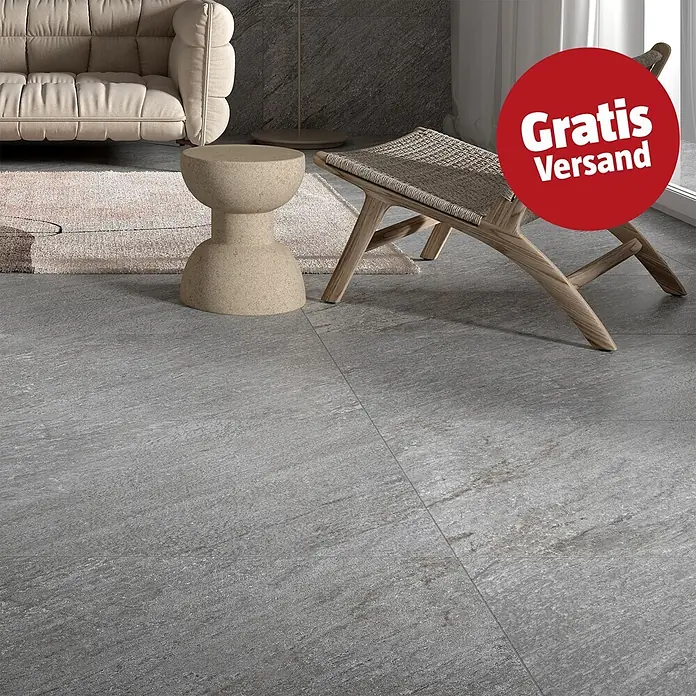 Feinsteinzeugfliese Piazza Grey - 59,7 x 119,7 cm, Grau, Matt - Graue, strukturierte Bodenfliesen in Steinoptik in einem modernen Wohnzimmer.