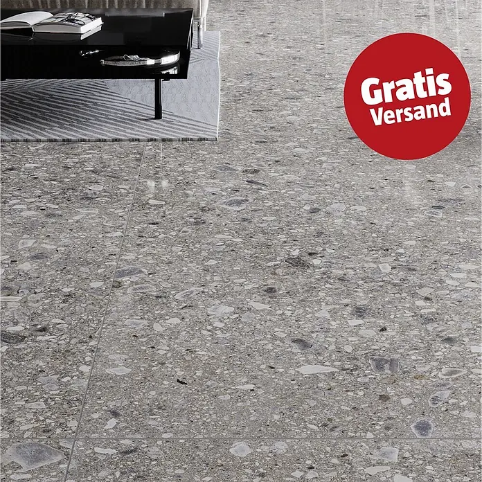 Feinsteinzeugfliese Terrazzo Ceppo - 59,7 x 119,7 cm, Graphit, Glänzend - Graue Terrazzo-Optik Bodenfliesen in Wohnzimmer-Umgebung, mit rotem "Gratis Versand" Aufkleber.