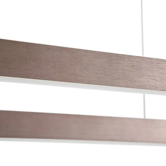 Lucande Pendelleuchte Melinay - L x B x H: 110 x 32 x 4,5 cm, braun / rost, kaffee - Zwei abgehängte, linear geformte Elemente aus texturiertem Bronzefarbton, vermutlich einer modernen Leuchte.
