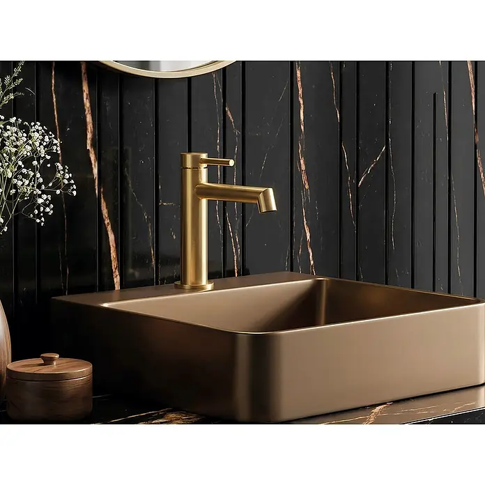 GME Grifo de lavabo Persio - Oro, Satinado - Grifo color oro sobre un lavabo rectangular marrón mate, instalado en un lujoso baño.