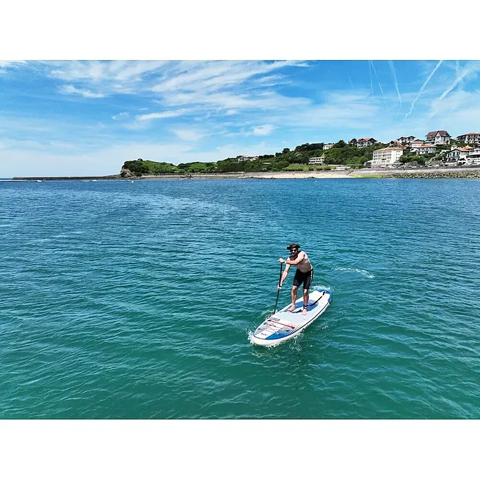 Aqua Marina SUP-Board-Set Magma 11,2" - L x B x H: 340 x 84 x 15 cm, Mehrfarbig, Tragkraft: 150 kg - Mann auf einem blau-weißen Stand-up-Paddleboard, paddelt im Meer.