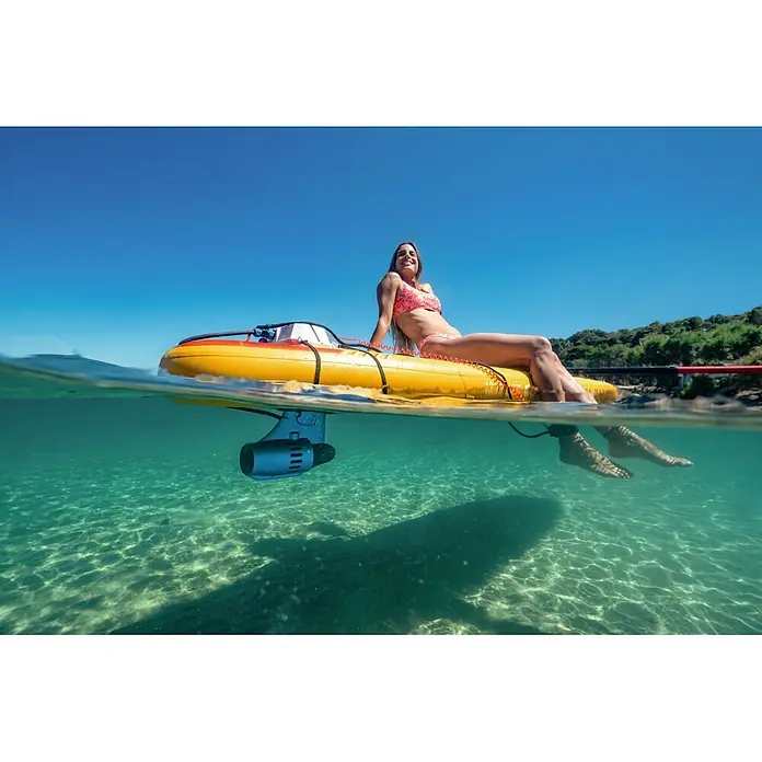 Aqua Marina SUP-Board-Set Fusion - L x B x H: 330 x 81 x 15 cm, Orange, Tragkraft: 150 kg - Frau im Bikini entspannt auf gelbem E-Paddleboard, dessen Motor im klaren Meerwasser untergetaucht ist.
