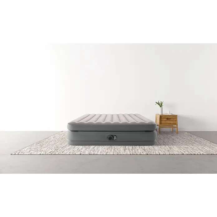Intex Luftbett Queen Comfort - L x B x H: 203 x 152 x 51 cm, Grau, Integrierte Luftpumpe - Graue aufblasbare Luftmatratze mit beiger Oberseite auf einem Teppich in einem modernen Raum.