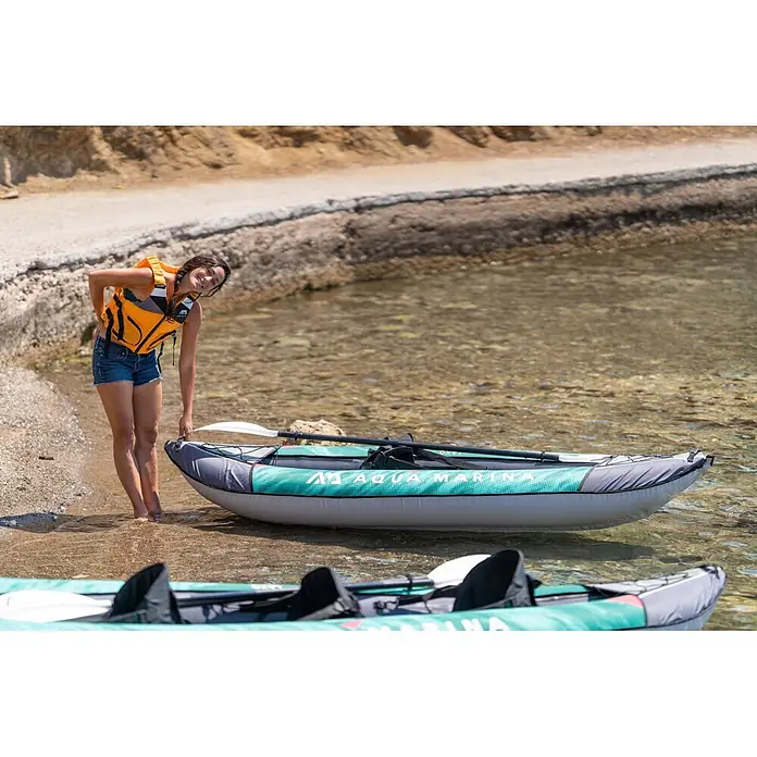 Aqua Marina Kajak Laxo 9'4" - L x B: 285 x 90 cm, Geeignet für: 1 Person, Tragkraft: 110 kg - Ein aufblasbares Aqua Marina Kajak in Türkis und Grau, im flachen Wasser, von einer Person für den Gebrauch vorbereitet.