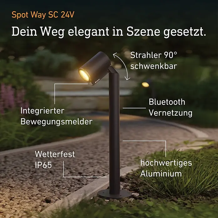 Steinel LED-Gartenstrahler Way SC 24V Garten-Lichtsystems - 363 lm, 1.800 K - 4.000 K, IP65 - Dunkle Aluminium-Wegeleuchte Spot Way SC 24V mit 90° schwenkbarem Kopf, integriertem Bewegungsmelder, Bluetooth und IP65 wetterfest, beleuchtet einen Gartenweg.