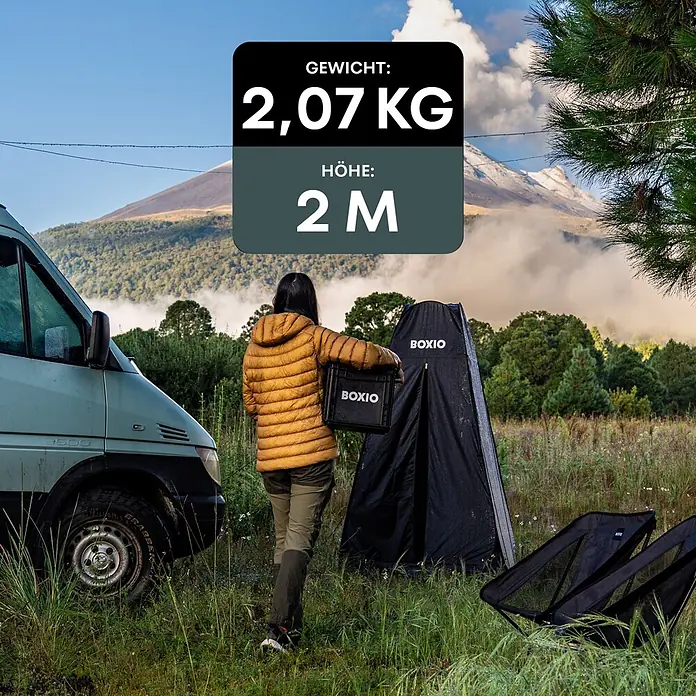 Boxio Zelt Dusche & Toilette - L x B x H: 63,5 x 63,5 x 6 cm, Schwarz - Schwarzes BOXIO-Privatzelt, Transportkiste und zwei tragbare Campingstühle im Freien aufgebaut.