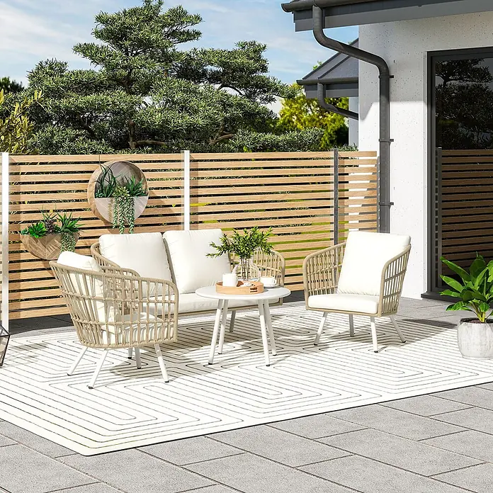 Outsunny Loungemöbel-Set - 4 -tlg., Stahl, PE-Rattan, Polyester, Schaumstoff, 2x Sessel, 1x Loveseat, 1x Tisch, 3x Sitzkissen, 4x Rückenkissen, 1x Bedienungsanleitung, Khaki - Garten-Sitzgruppe mit hellem Rattan-Sofa, zwei passenden Stühlen mit weißen Kissen und einem weißen runden Couchtisch auf einem gemusterten Teppich.
