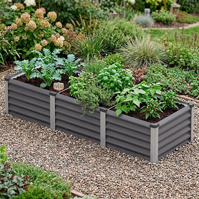 Vitavia Hochbeet Meta In&Out 401 - 185 x 65 x 40 cm, Zincalume®, Granit/Silber - Zwei dunkelgraue Hochbeete aus Metall, verbunden, gefüllt mit Erde, Gemüse und Kräutern, auf Kieselsteinen.