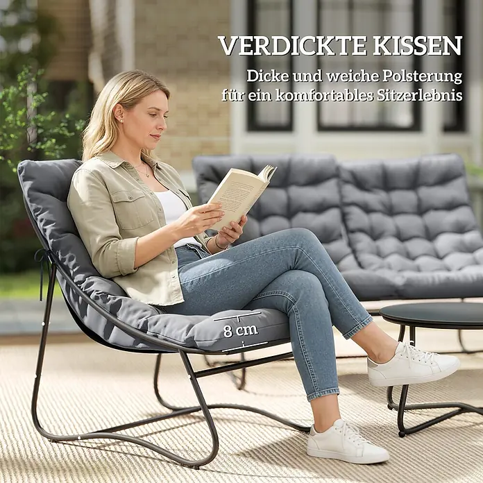 Outsunny Loungemöbel-Set mit Tisch - Stahl, Netzgewebe, Schaumstoff, Metall, 1x Couchtisch, 1x Sofa, 2x Stuhl, 4x Sitz- und Rückenkissen, 1x Handbuch, Grau - Frau liest auf einem grauen Outdoor-Loungesessel mit dicken 8 cm Kissen. Ein weiterer Stuhl und ein Tisch sind in der Nähe.
