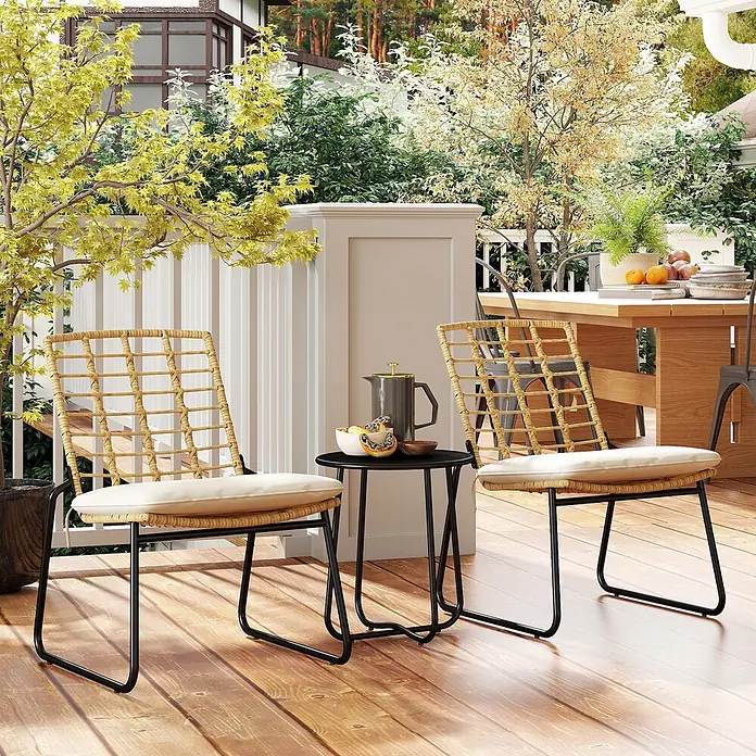 Outsunny Loungemöbel-Set mit Tisch - Stahl, Rattan, Metall, Polyester, PE-Rattan, Schaumstoff, 1x Tisch, 2x Stuhl, 2x Sitzkissen, 1x Handbuch, Beige - Zwei Outdoor-Stühle mit Rattangeflecht, cremefarbenen Kissen und schwarzen Metallgestellen flankieren einen schwarzen Beistelltisch auf einer Holzterrasse.