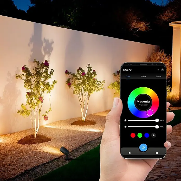 Hama LED-Gartenstrahler WLAN Gartenstecker - Schwarz - Hand hält Smartphone zur Steuerung von Gartenleuchten mit farbiger App bei Nacht.