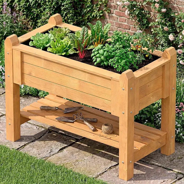 Promadino Kräuterhochbeet - 114 x 60 x 84,5 cm, Honigbraun - Holz-Hochbeet mit Ablage, bepflanzt, Gartengeräte darauf im Garten.