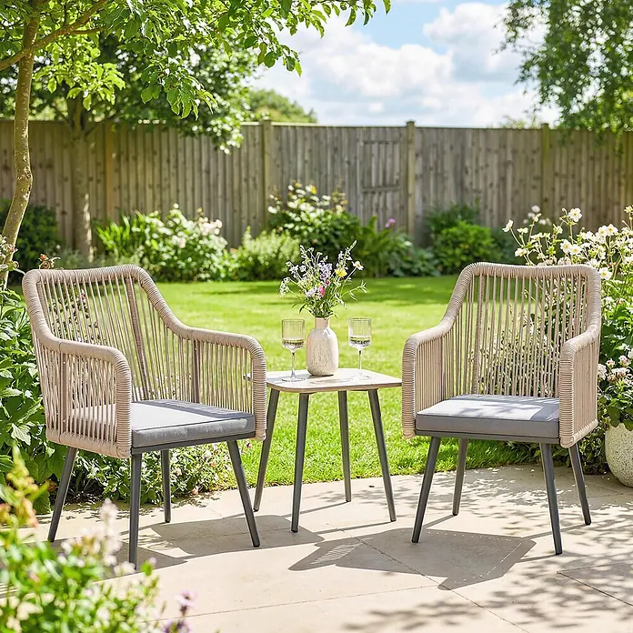 Outsunny Gartenstuhl-Set - 2 Stk., Stahl; PE-Rattan (Polyethylen-Geflecht, witterungsbeständig), Hellgrau, B x T x H: 54 x 65 x 80 cm - Zwei beigefarbene Rattan-Gartensessel mit grauen Kissen und ein passender kleiner Tisch auf einer Terrasse im Garten.