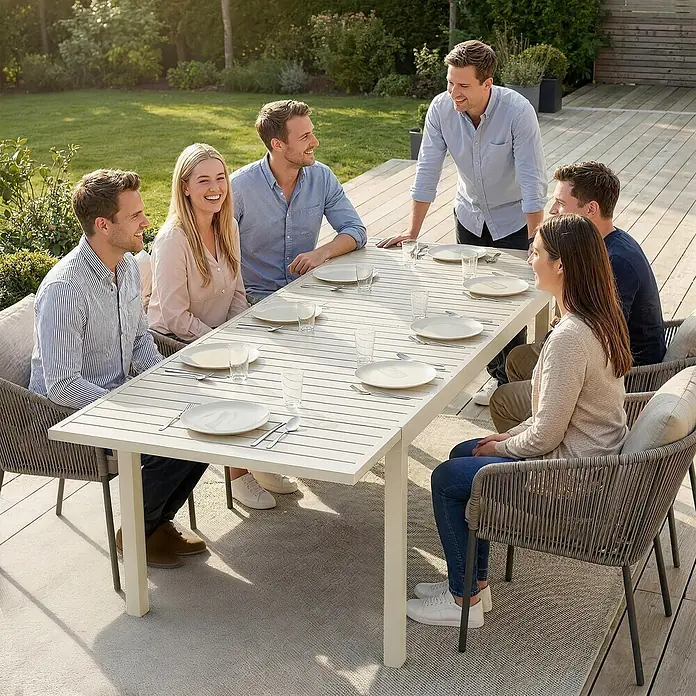 Outsunny Gartentisch - L x B x H: 225 x 85 x 75 cm, Aluminium, Weiß - Helle, lattenförmige Gartentafel mit grauen Korbstühlen, genutzt von sechs Personen im Garten.
