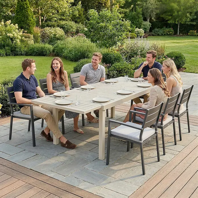 Outsunny Gartentisch - L x B x H: 225 x 85 x 75 cm, Aluminium, Weiß - Gartensitzgruppe: heller Tisch mit Lattenplatte, dunkelgraue Stühle mit hellen Polstern, von sechs Personen im Garten genutzt.