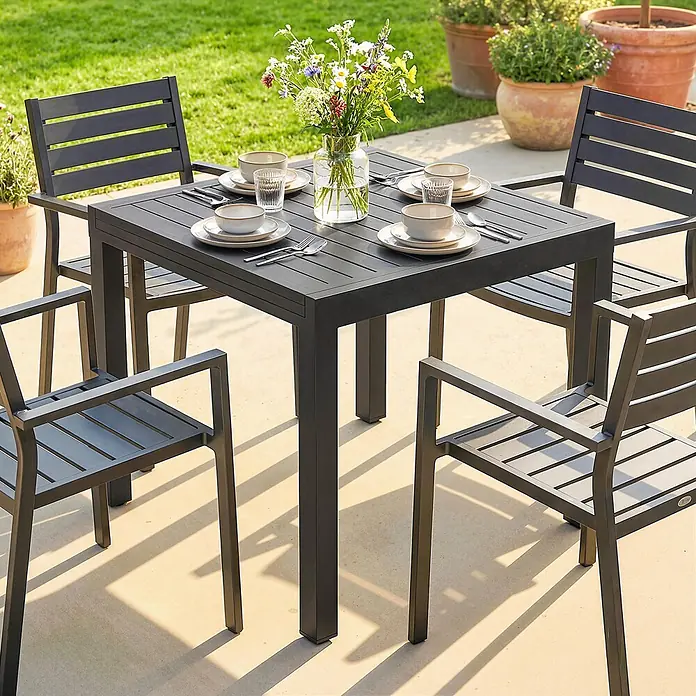 Outsunny Gartentisch - L x B x H: 160 x 80 x 75 cm, Aluminium, Schwarz - Dunkelgraues Outdoor-Essgruppe mit quadratischem Aluminiumtisch und vier Lamellenstühlen auf einer Terrasse.