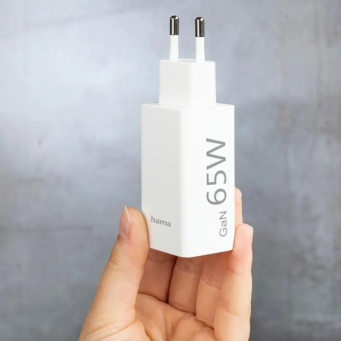 Hama USB-Adapter 00200016 GaN Power Delivery (PD) 5-20V/65W - Weiß - Weißes Hama GaN 65W USB-C Ladegerät mit zwei Stiften, in einer Hand gehalten.