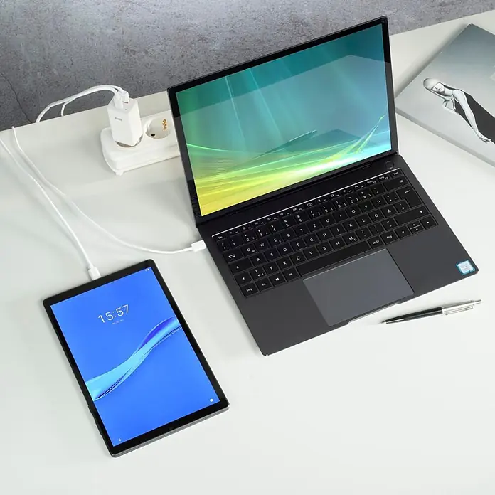 Hama USB-Adapter 00200016 GaN Power Delivery (PD) 5-20V/65W - Weiß - Schwarzes Laptop und Tablet laden über weiße Kabel von einer weißen Steckdosenleiste auf einem Schreibtisch.