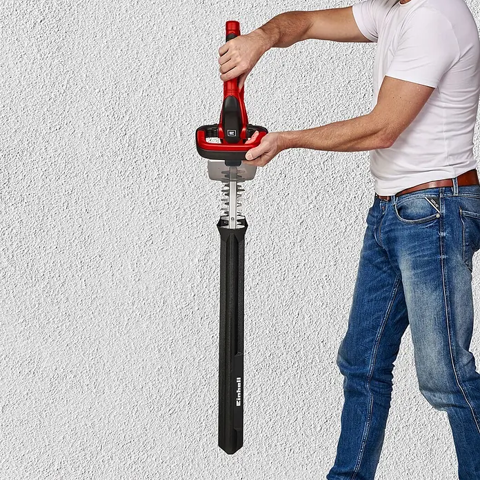 Einhell Power X-Change 18V Akku-Heckenschere GC-CH 1855/1 LI - 18 V, Li-Ionen, 1 Akku, Schnittlänge: 55 cm - Person setzt schwarze Schutzhülle auf rote und schwarze Heckenschere.
