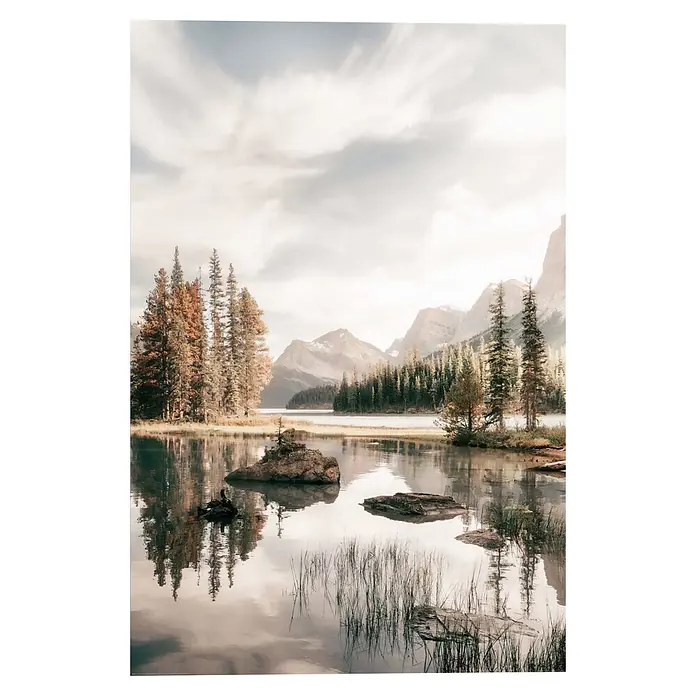 Reinders Decopanel - Spirit Island, B x H: 60 x 90 cm - Ruhiger See spiegelt Kiefern und Berge unter bewölktem Himmel. Felsen und Gras im Vordergrundwasser sichtbar.
