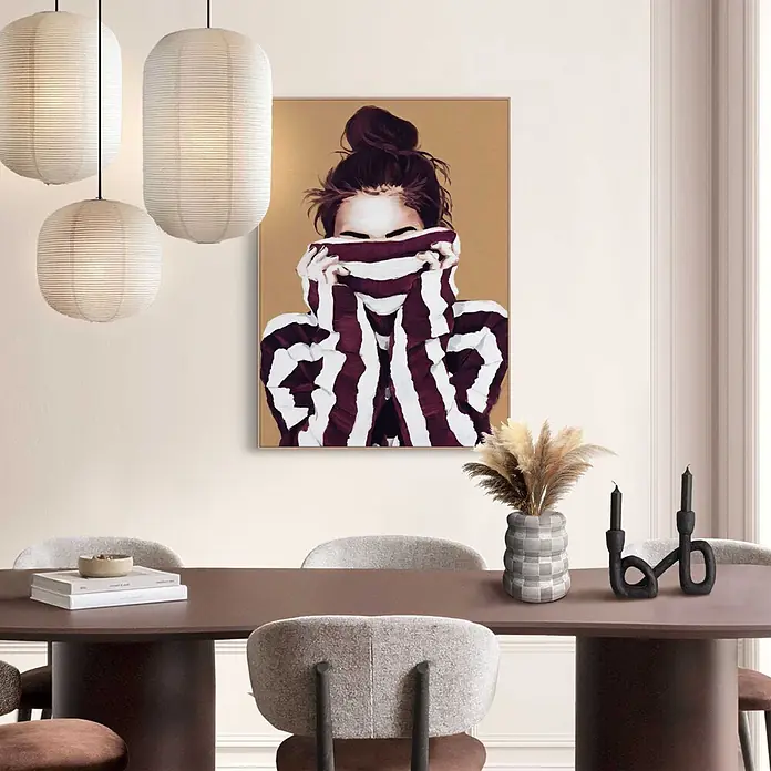 Reinders Bild Slim Frame Wood - Hiding, B x H: 50 x 70 cm - Moderner Essbereich mit dunkelbraunem Rundtisch, hell gepolsterten Stühlen, drei weißen Papier-Pendelleuchten und einem großen Gemälde einer Frau in Streifen.