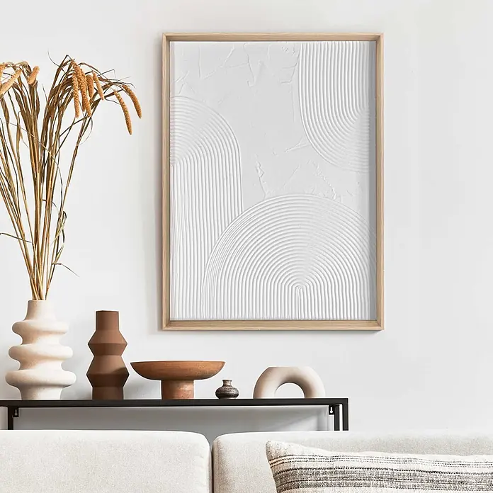 Reinders Bild Craft Art - Thin Comb, B x H: 30 x 40 cm - Ein weißes Strukturbild mit gewölbten Mustern in einem hellen Holzrahmen, über einem Regal und Sofa hängend.