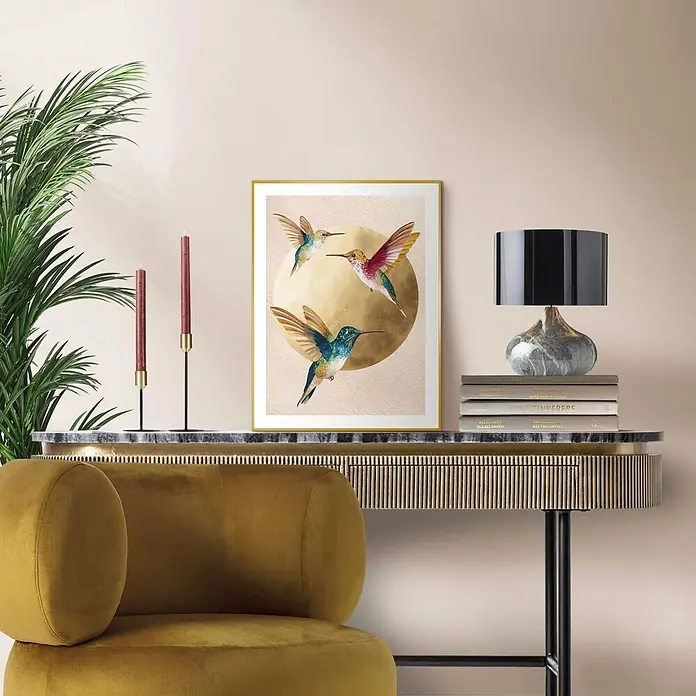 Reinders Bild Slim Frame Gold - Dancing Hummingbirds, B x H: 30 x 40 cm - Gerahmter Kunstdruck mit drei farbenfrohen Kolibris um eine goldene Sonne, an einer Wand über einer Konsole.