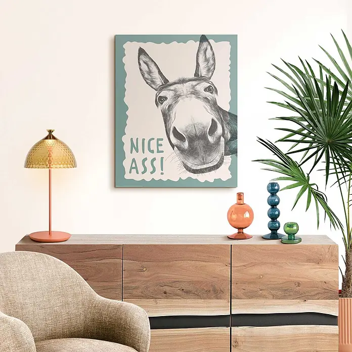 Reinders Decopanel - Nice Ass, B x H: 40 x 50 cm - Humorvolles Esel-Poster mit 'Nice Ass!' Text, hängt über einem Holz-Sideboard in einem Wohnzimmer.