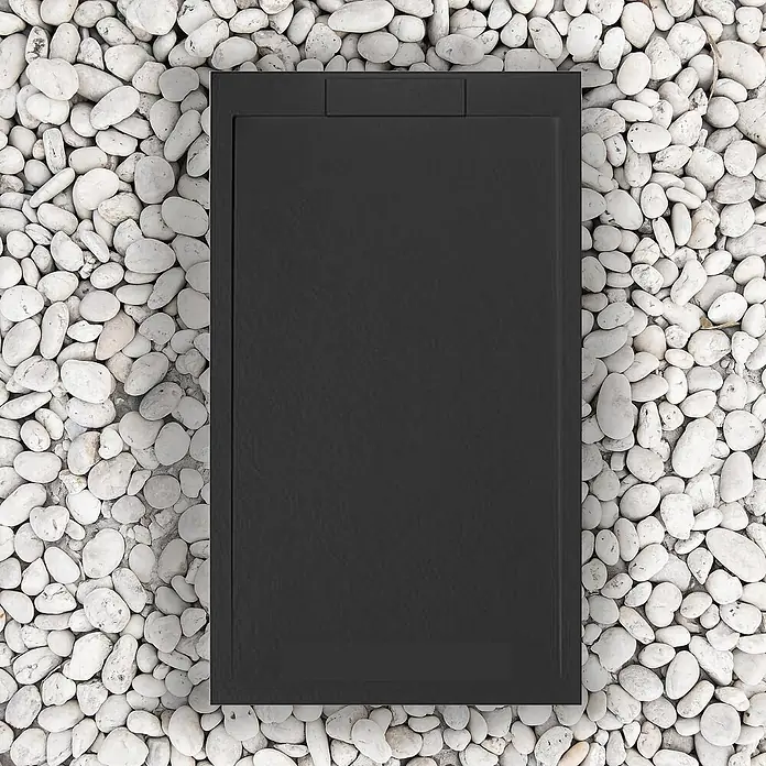 FRASCIO New Tecnology Duschwanne Duschwanne - L x B: 1.200 x 900 mm, Verbundwerkstoff, Schwarz - Dunkelgraue, rechteckige strukturierte Duschwanne, umgeben von weißen Kieselsteinen.